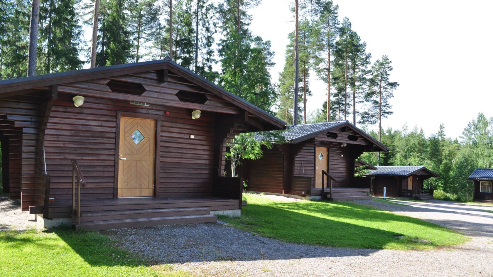 Kolme kesärannan mökkiä rivissä.