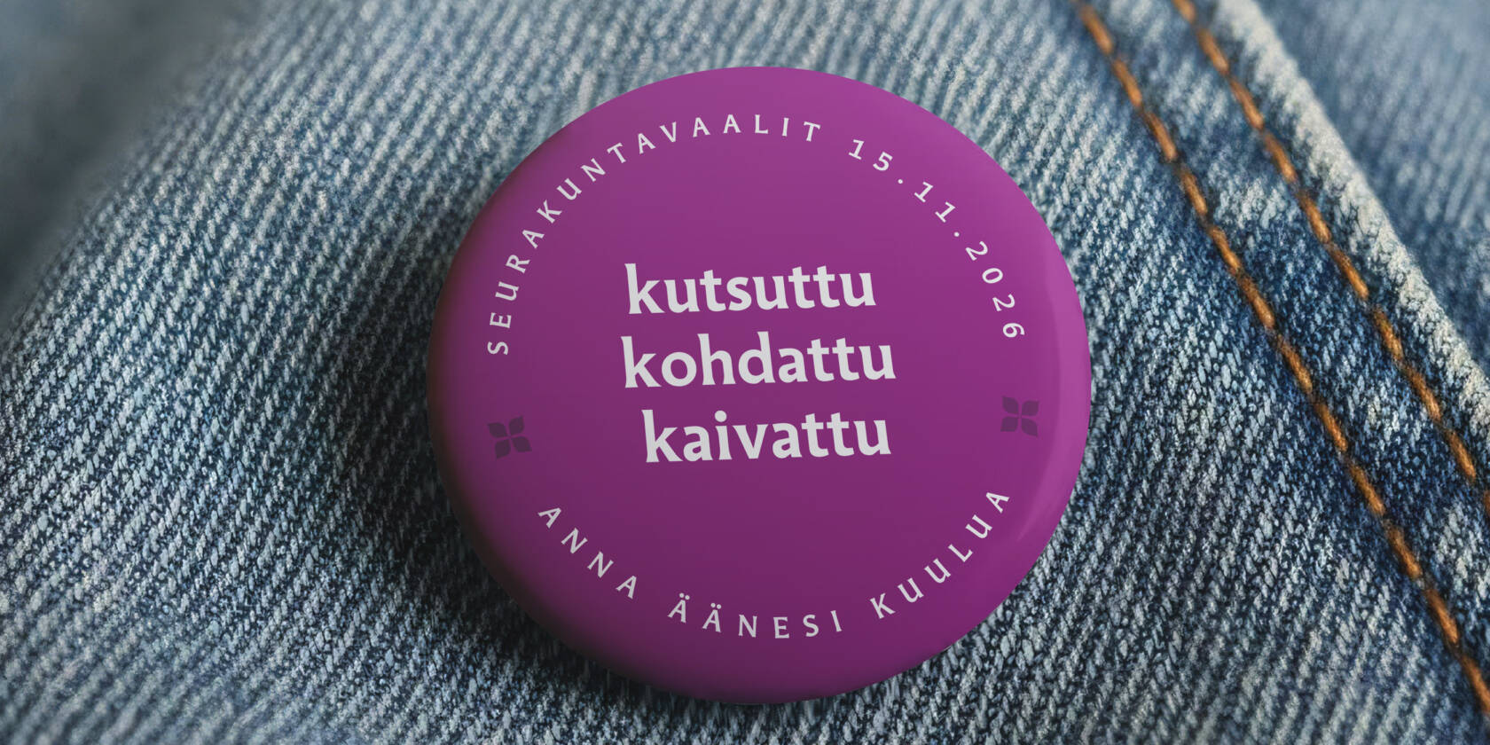 Violetti rintamerkki farkkukankaalla. Rintamerkissä teksti: ‘Seurakuntavaalit 15.11.2026 – kutsuttu, kohdattu, kaivattu – anna äänesi kuulua’