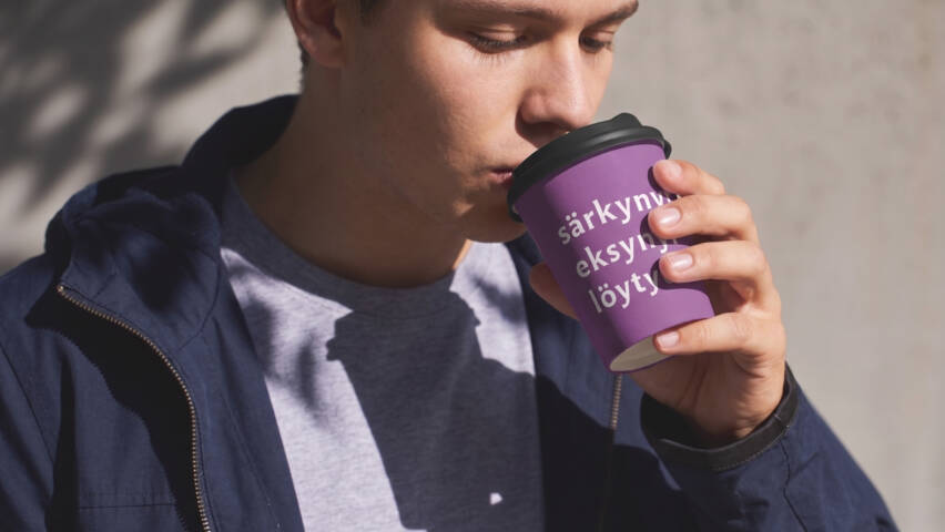 Henkilö juo violetista mukista, jossa lukee ”särkynyt, eksynyt, löytynyt”.