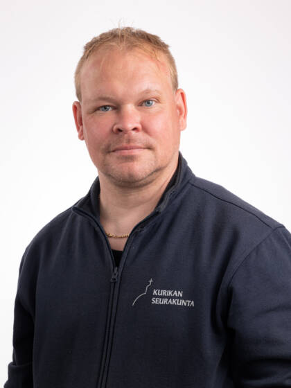 Vaaleahiuksinen mies, jolla tummansininen paita.