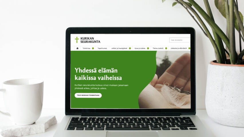 Kannettava tietokone, jonka näytöllä näkyvät Kurikan seurakunnan uudet verkkosivut.